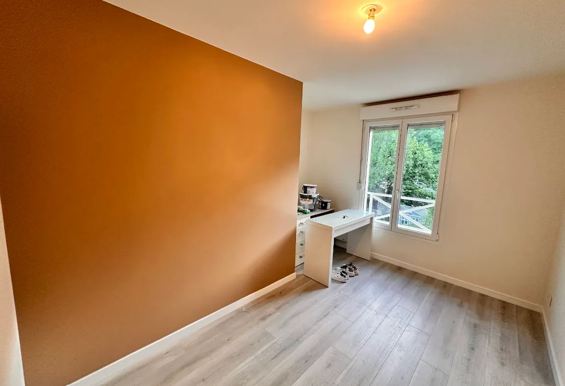 Chambre avec un mur d’accent terracotta et des murs blancs