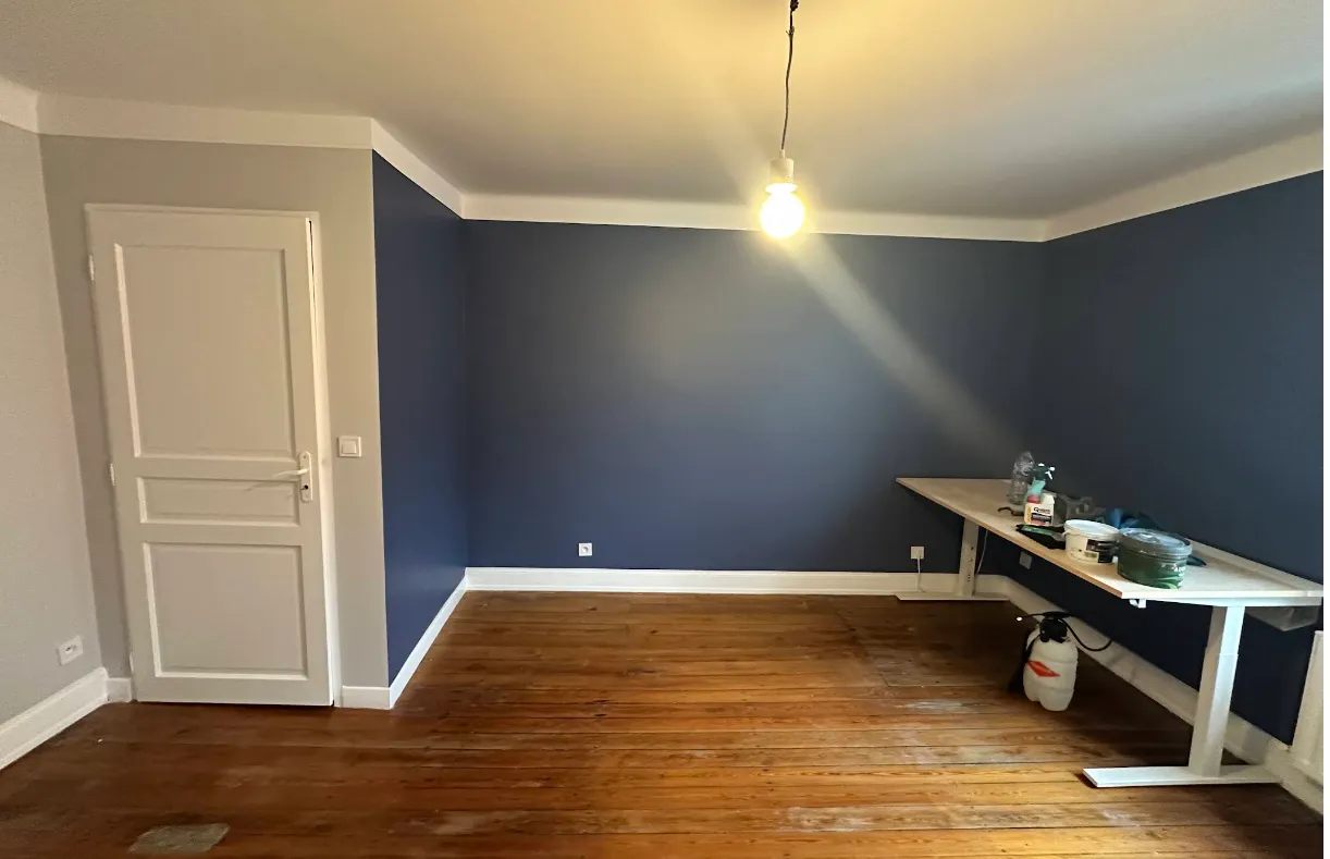 Pièce aux murs bleu nuit avec plafond et corniches blancs